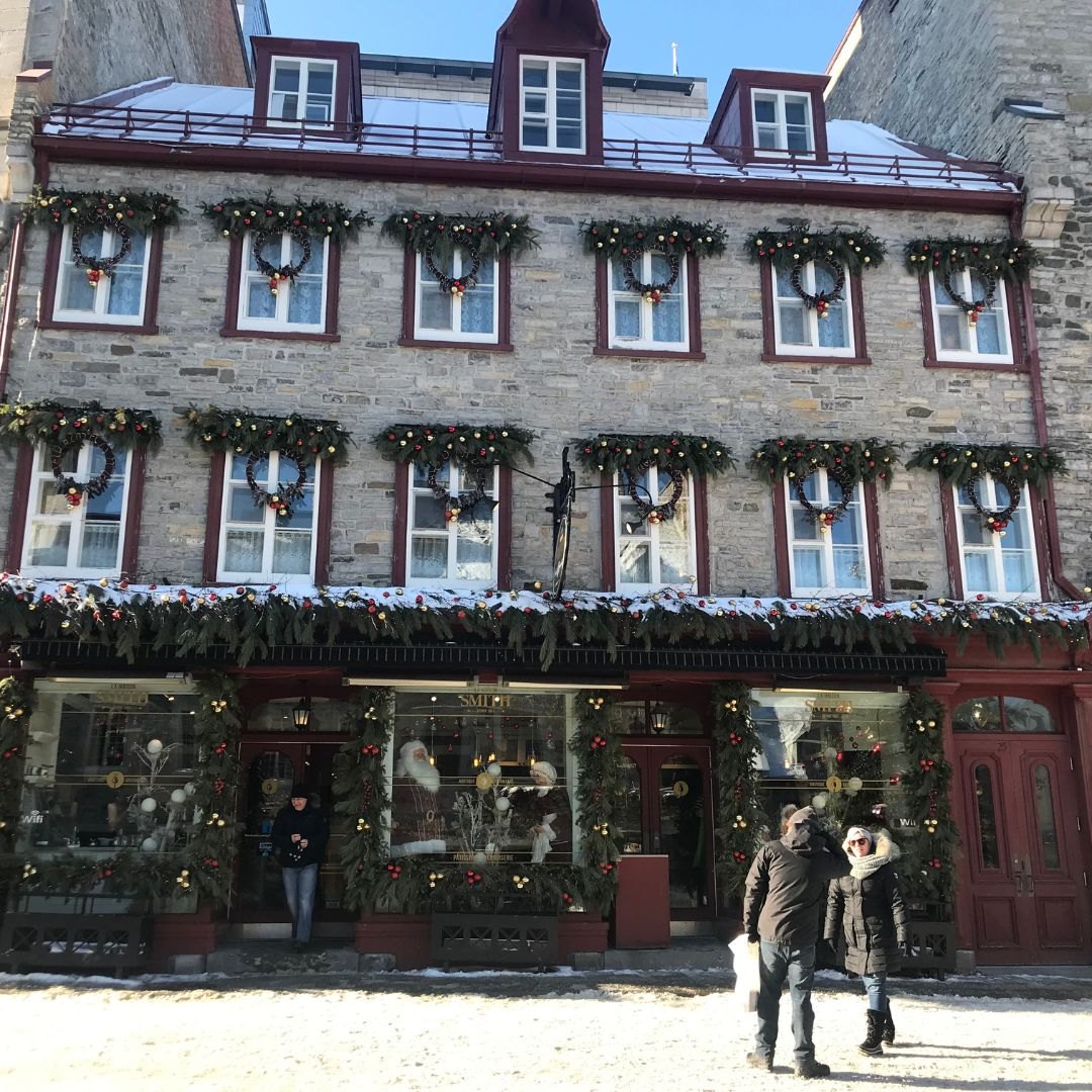 A snowy street in Old Québec lined with stone buildings.